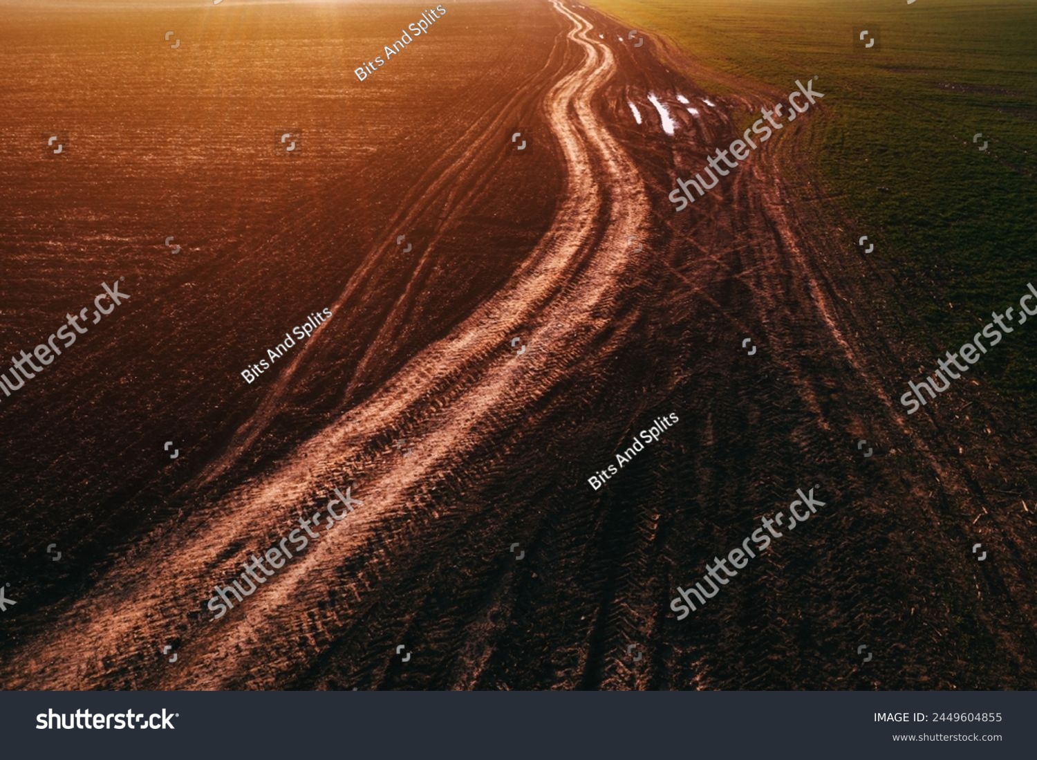 Dirt road with tractor tire track pattern in diminishing perspective, aerial view from drone pov high angle view #2449604855
