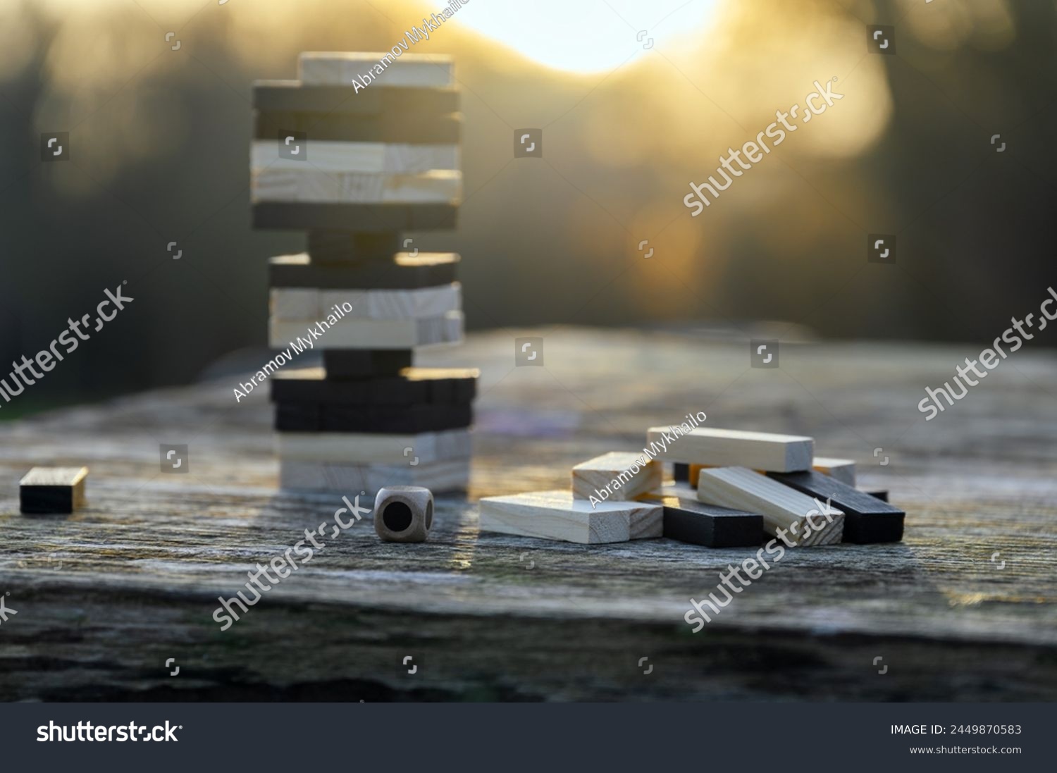 Peaceful rest in nature in sunny weather. The game "Jenga", "Wooden tower" against the background of nature. Concentration, calmness, choice, decision-making. High quality photo #2449870583