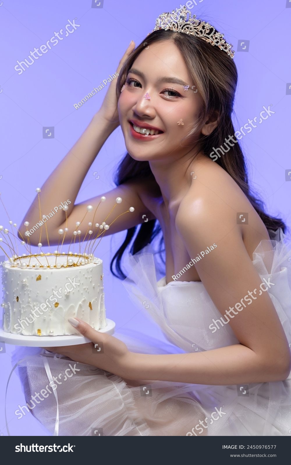 Happy beautiful Asian girl in princess dress showing birthday cake. Birthday princess photography theme is popular in social network. #2450976577