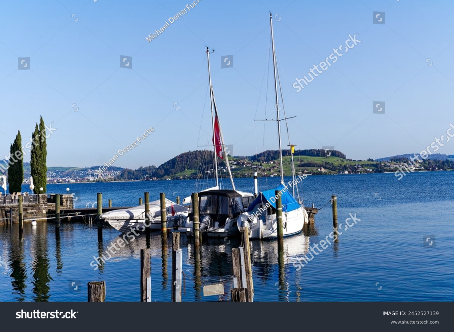 Scenic view of port at lakeshore of Lake Lucerne at Swiss village of Stansstad on a sunny spring morning. Photo taken April 11th, 2024, Stansstad, Switzerland. #2452527139