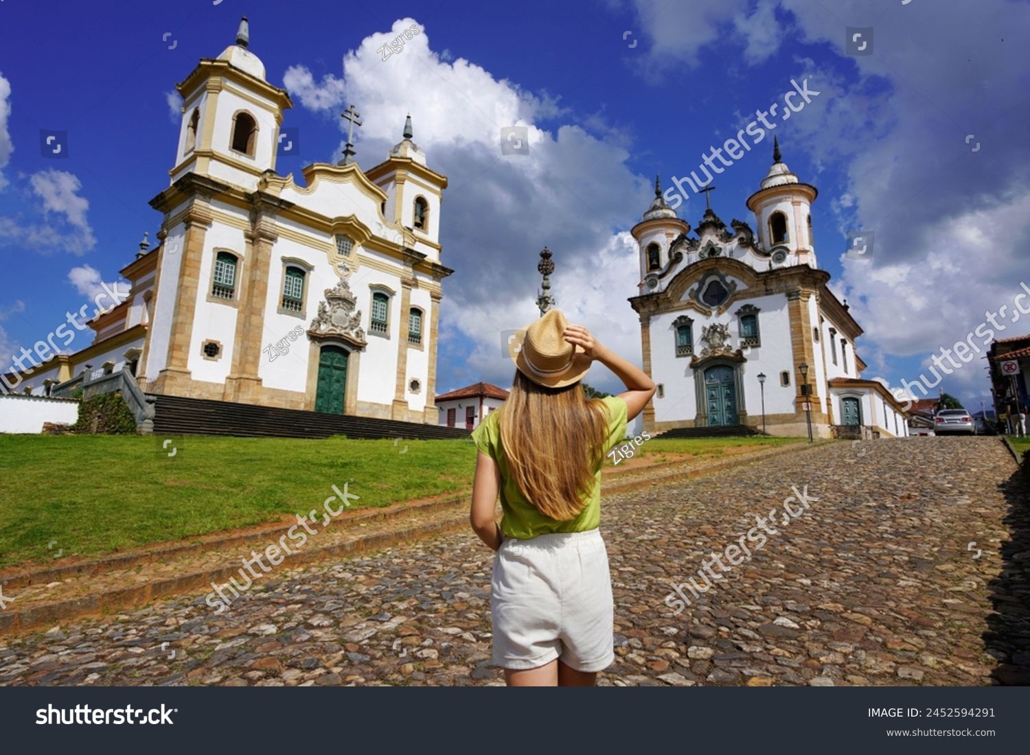 Holidays in Minas Gerais, Brazil. Back view of traveler girl visiting historical town of Mariana with baroque colonial architecture. Mariana is the oldest city in the state of Minas Gerais, Brazil. #2452594291