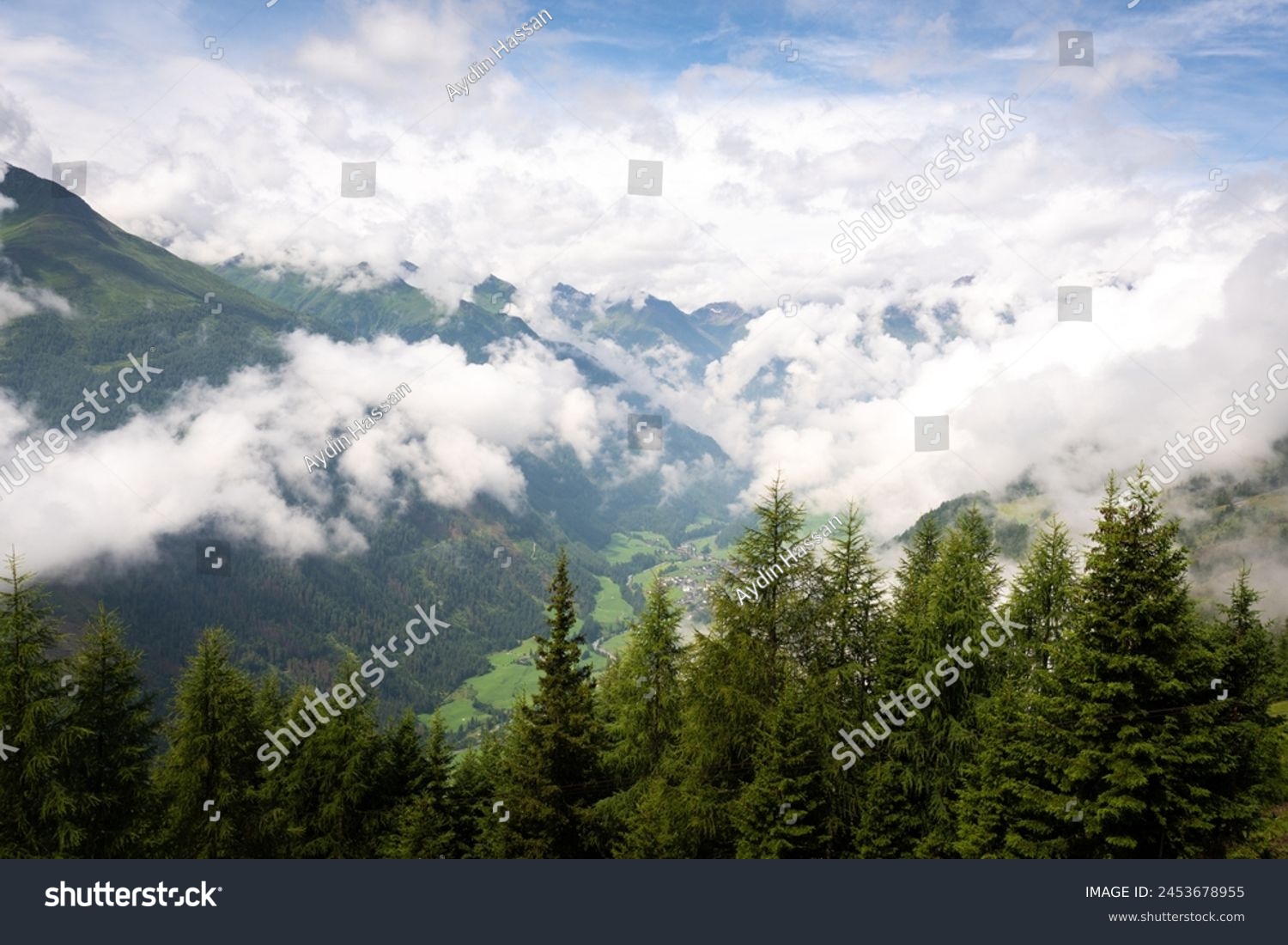 The sun shines after a huge rain storm and clouds begin to scatter revealing the lush green valley floor, Hohe Tauern National Park, Osttirol, Austria #2453678955
