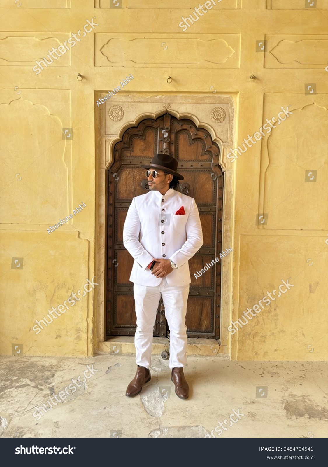 graceful man showcases cultural elegance in traditional attire, exuding confidence and heritage in a single pose #2454704541