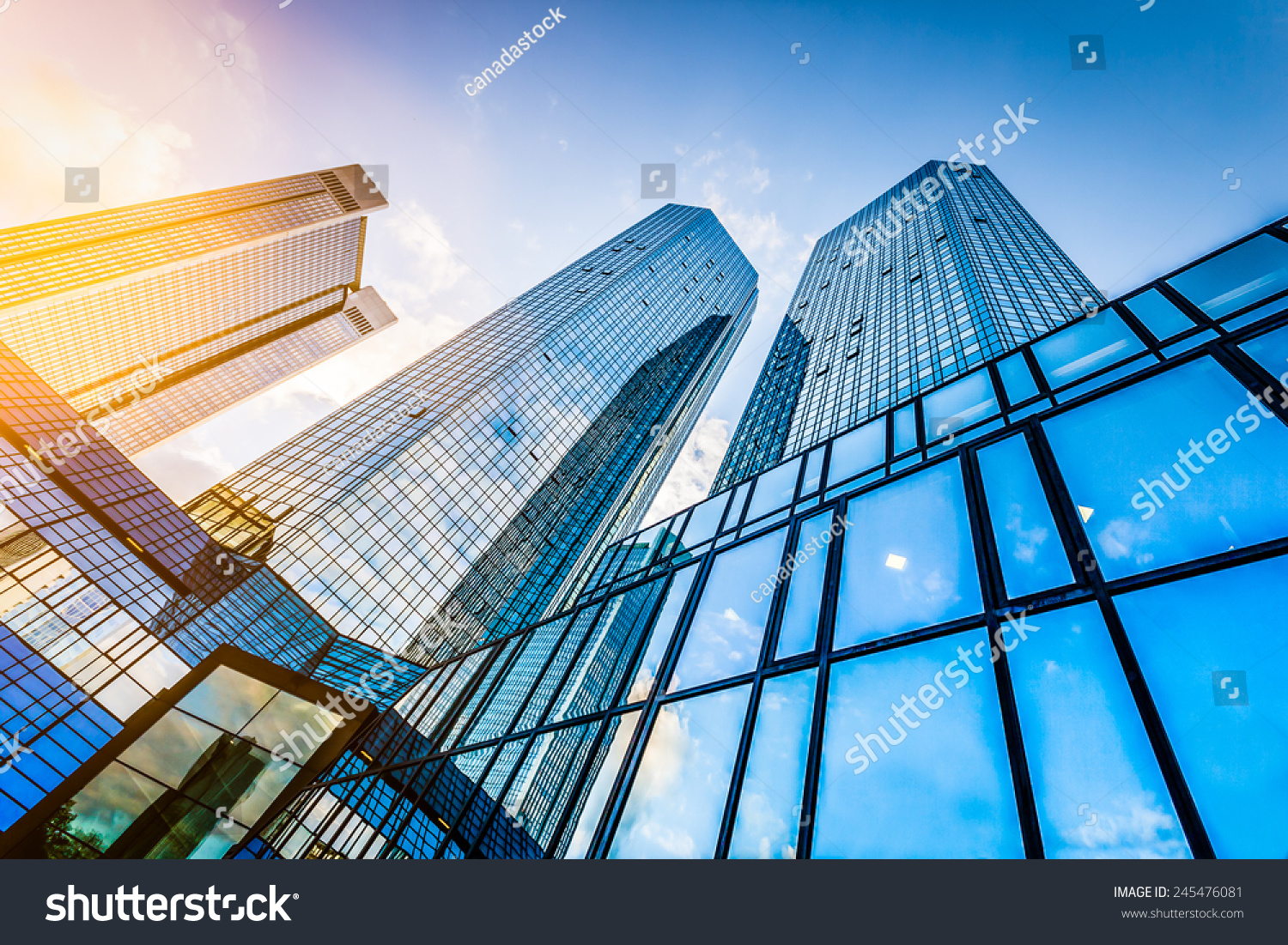 Bottom view of modern skyscrapers in business district at sunset with lens flare filter effect #245476081