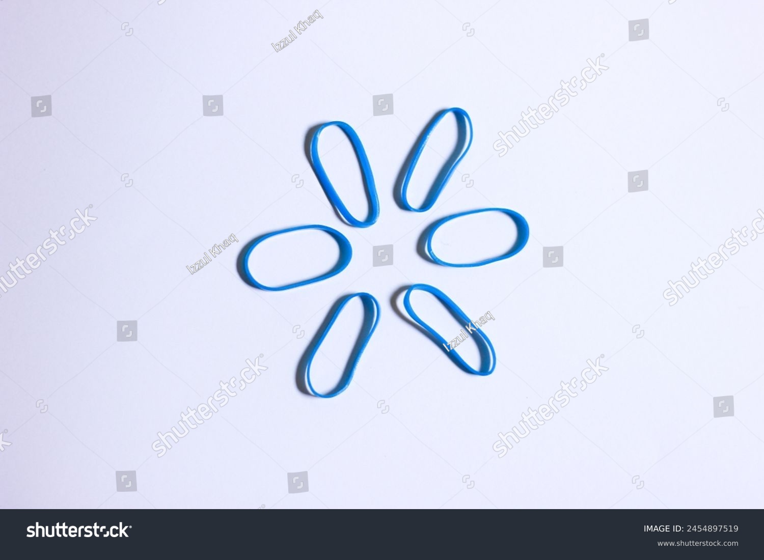 blue vibrant colored mini rubber band isolated on white background forming a hexagon shape look alike, conceptual photo illustration #2454897519