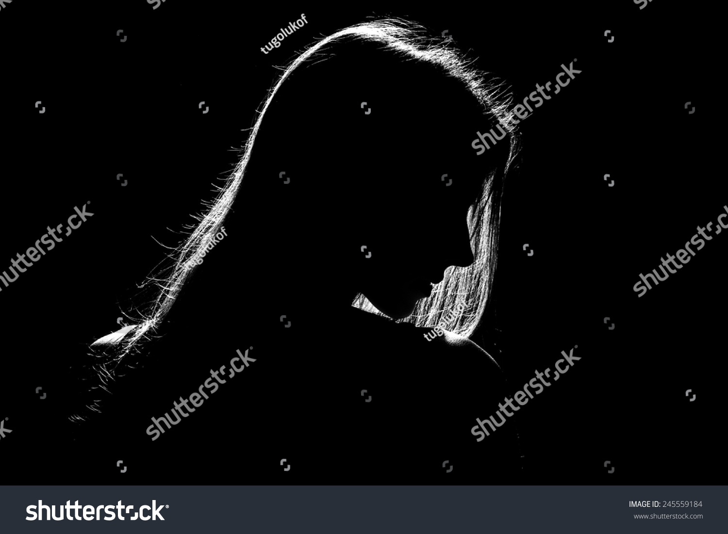 sad woman profile silhouette in dark, monochrome image #245559184