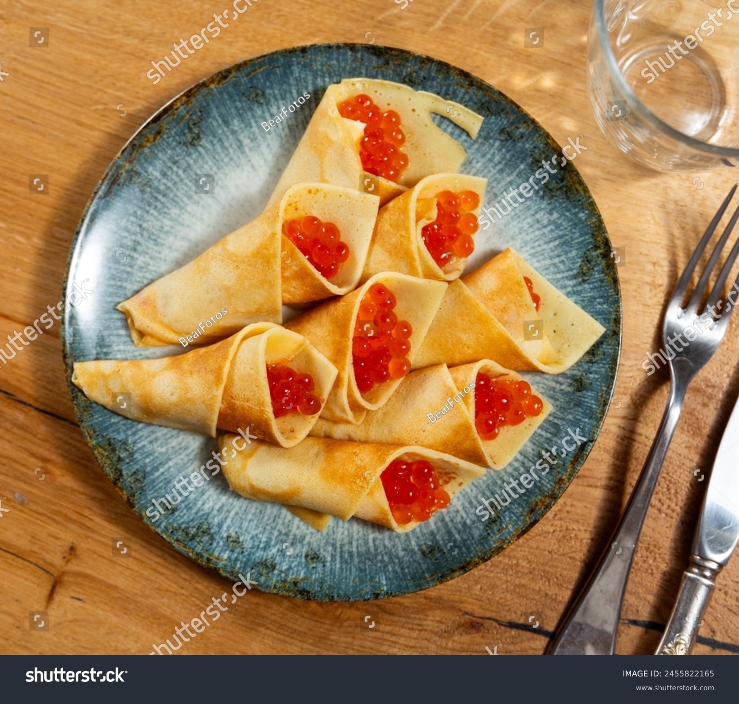 Pancakes with red caviar dished up in flat service plate. Traditional Russian cuisine #2455822165