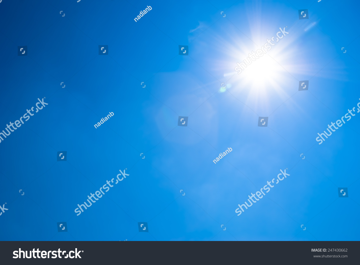 Bright blue sky and sun with flecks of sunlight #247430662