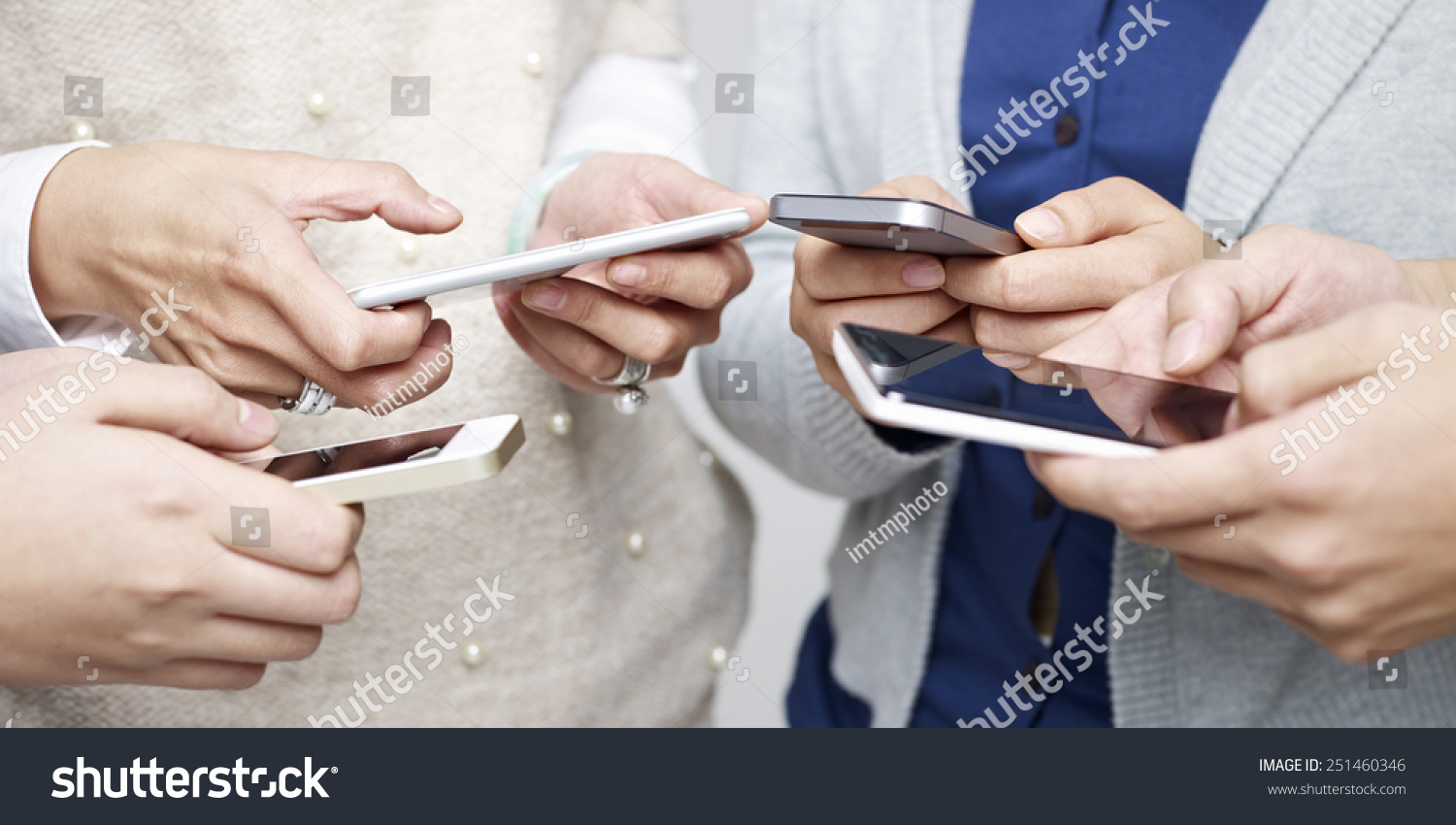 small group of people using cellphones together. #251460346