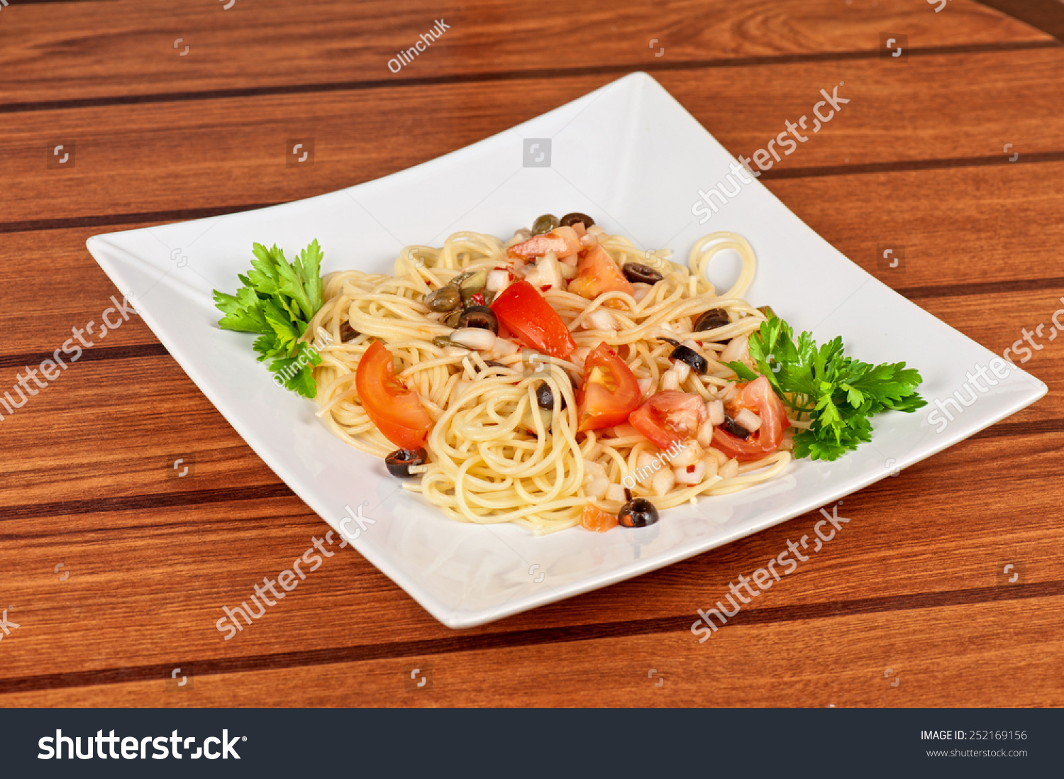 Pasta with tomato, black olives, capers and greens #252169156
