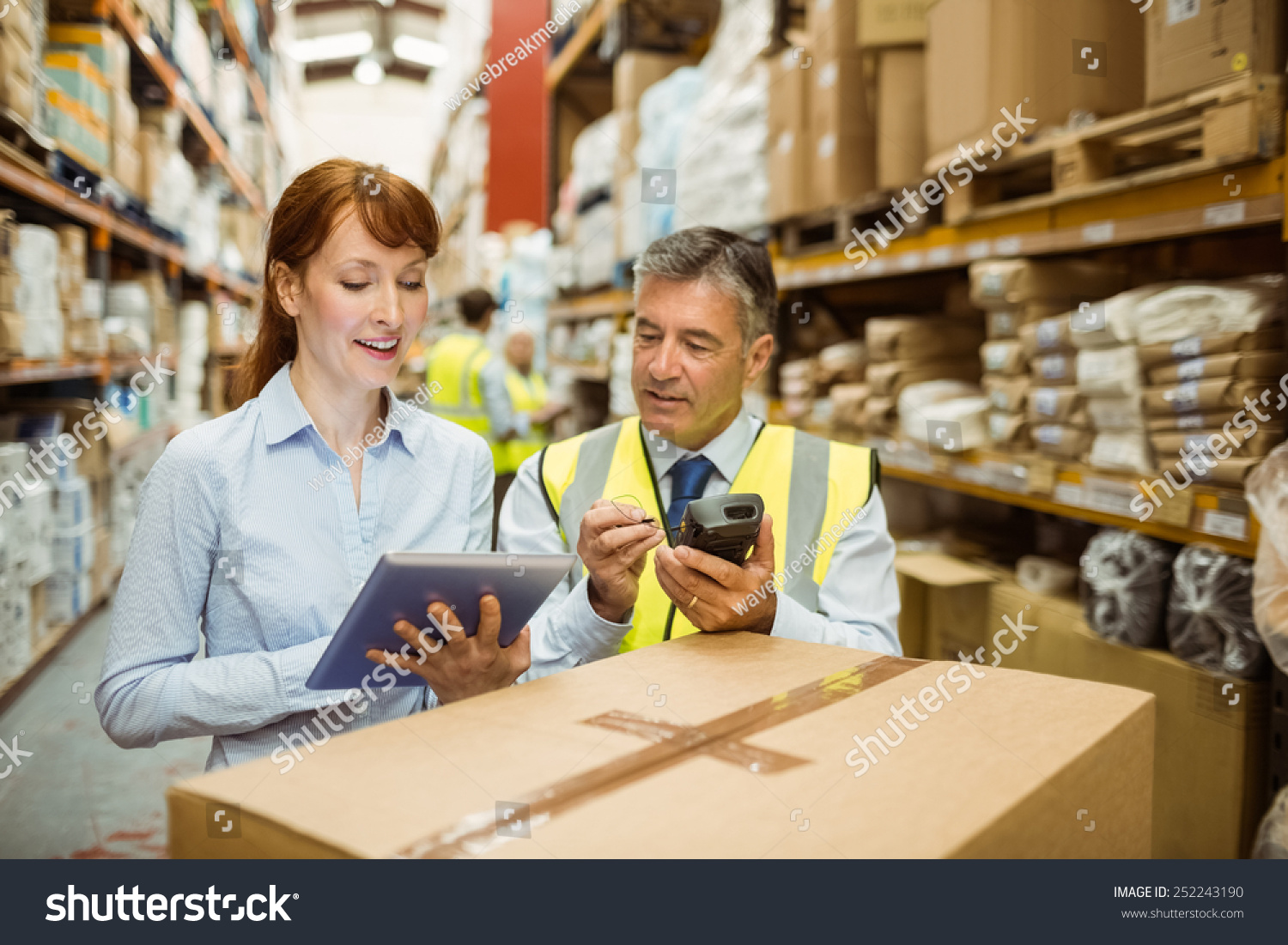 Close up of warehouse managers looking at tablet pc in a large warehouse #252243190