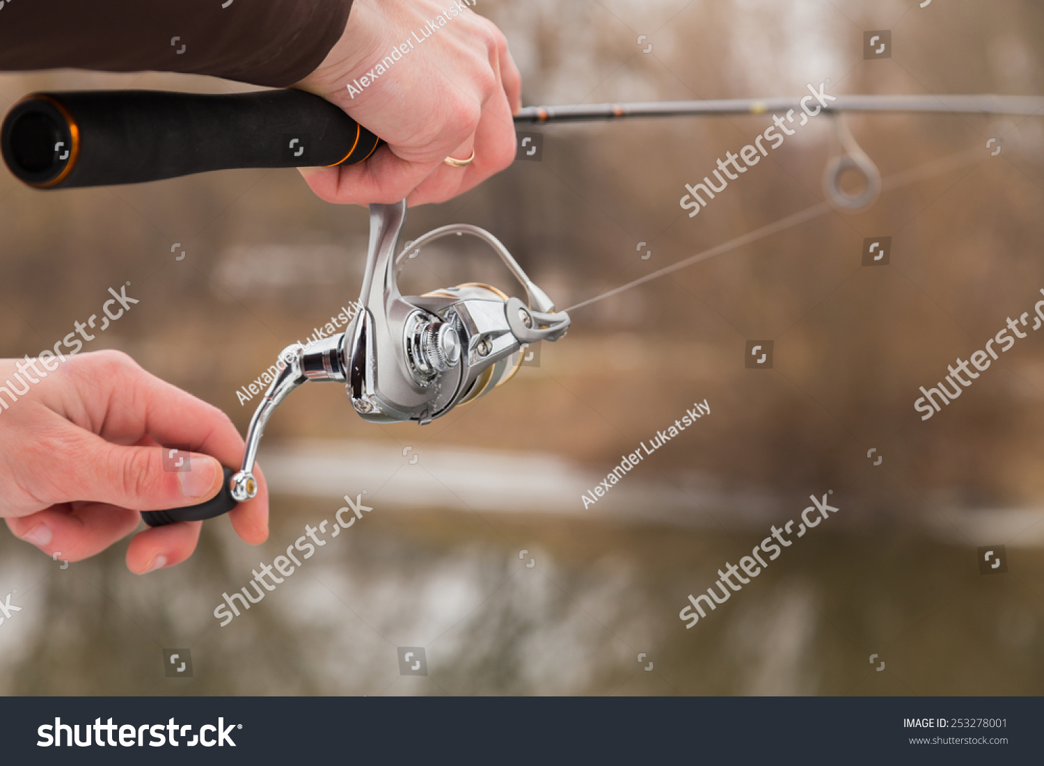 Winter spinning. Fishing in winter. Fisherman on the river bank. Fisherman holding a light spinning rod in his hand. Suburban recreation, sport fishing. Active Life on a fishing trip. #253278001