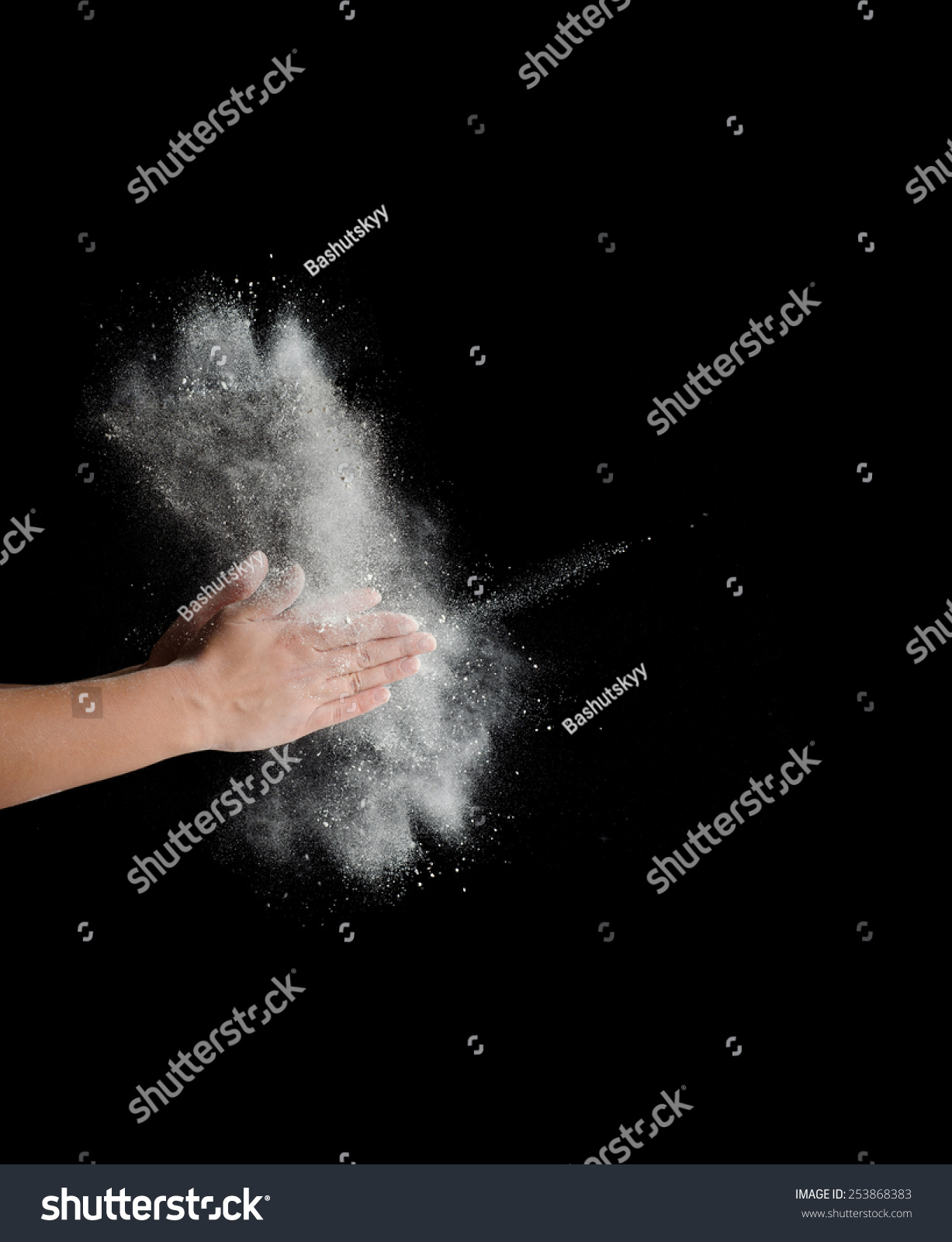 Freeze motion of dust explosion in hands isolated on black background #253868383