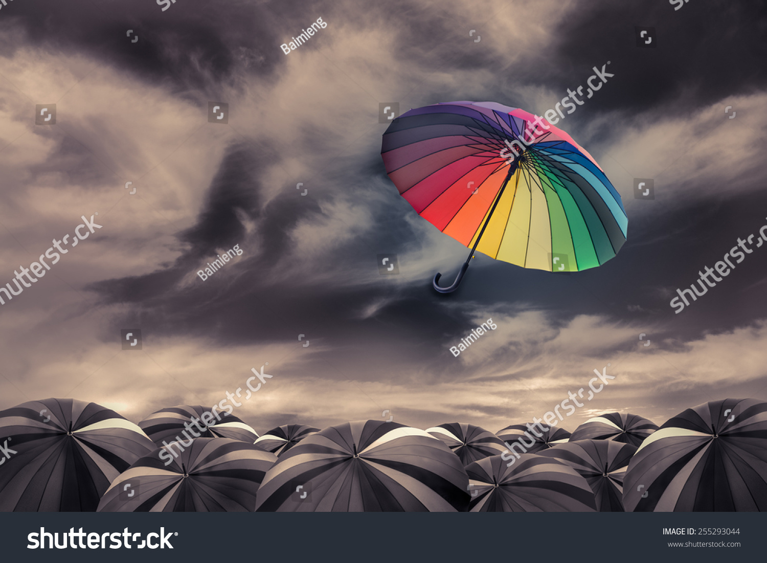 rainbow umbrella fly out the mass of black umbrellas #255293044