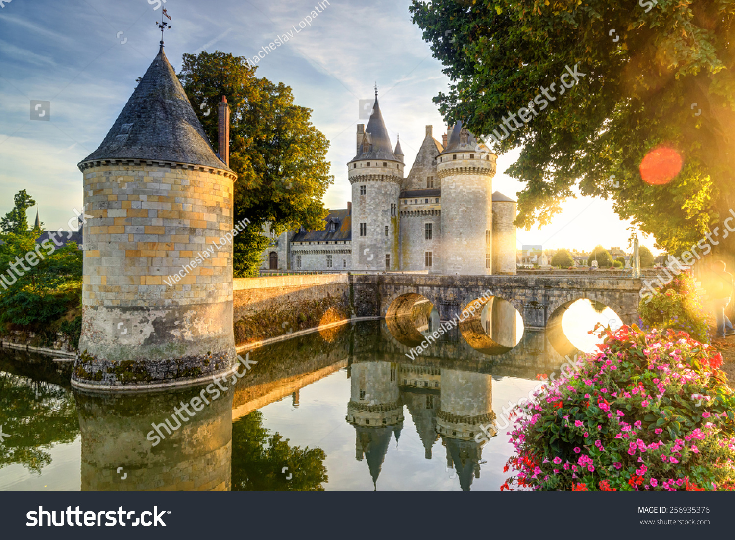 Castle Chateau de Sully-sur-Loire at sunset, France. It is famous landmark of Loire Valley. Beautiful sunny view of medieval castle, nice landscape of old France in summer. Sightseeing, travel theme  #256935376