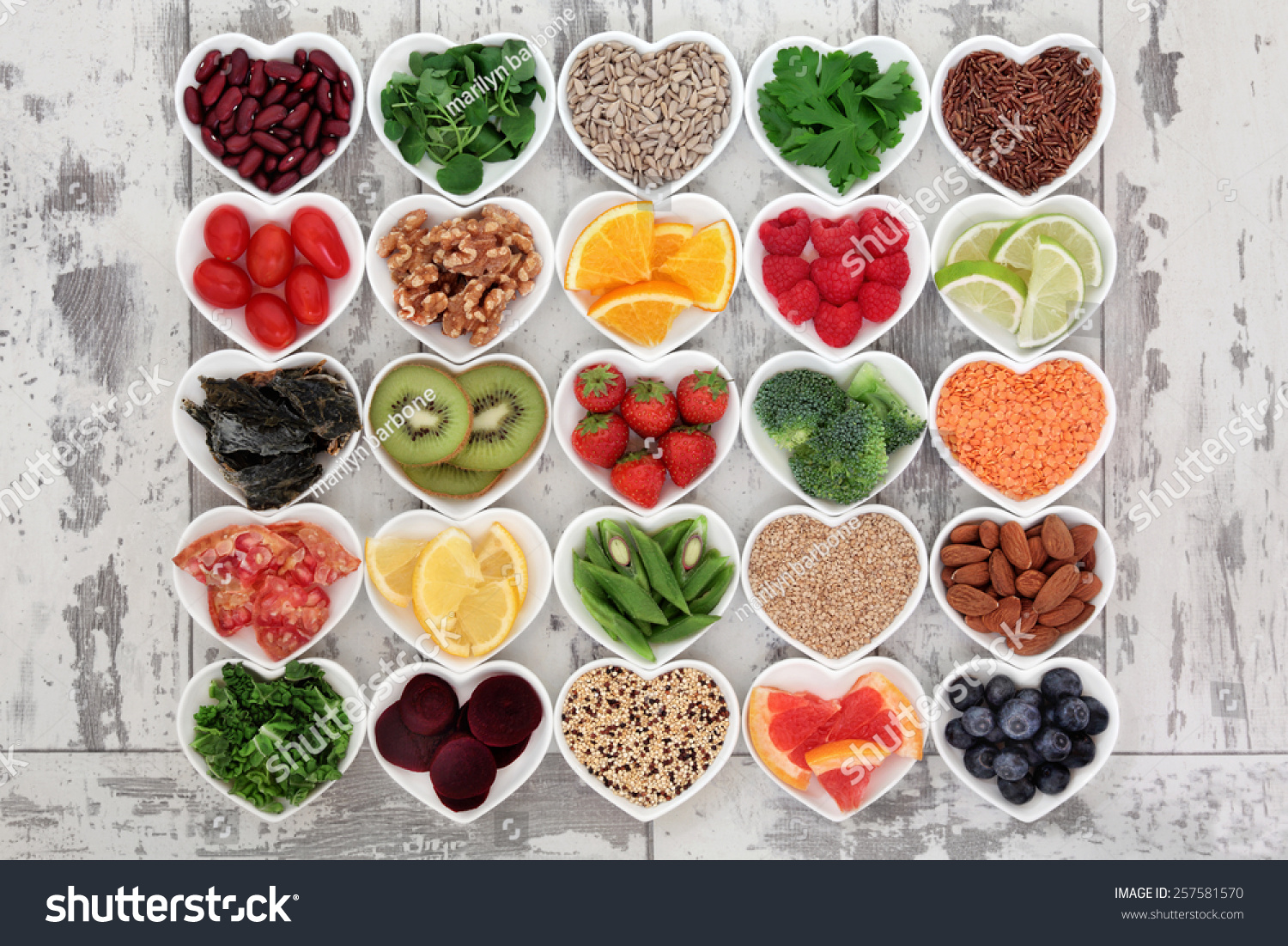 Diet detox super food & immune boosting food collection in heart shaped porcelain bowls over rustic wood background. Foods high in antioxidants, anthocaynins, omega 3, protein, vitamins & minerals.   #257581570