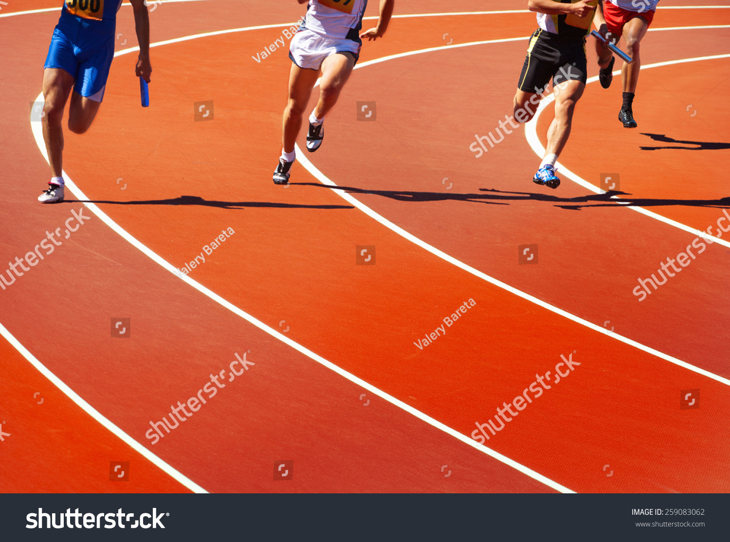 Running athletes at stadium in relay race athletics competition 
 
 #259083062