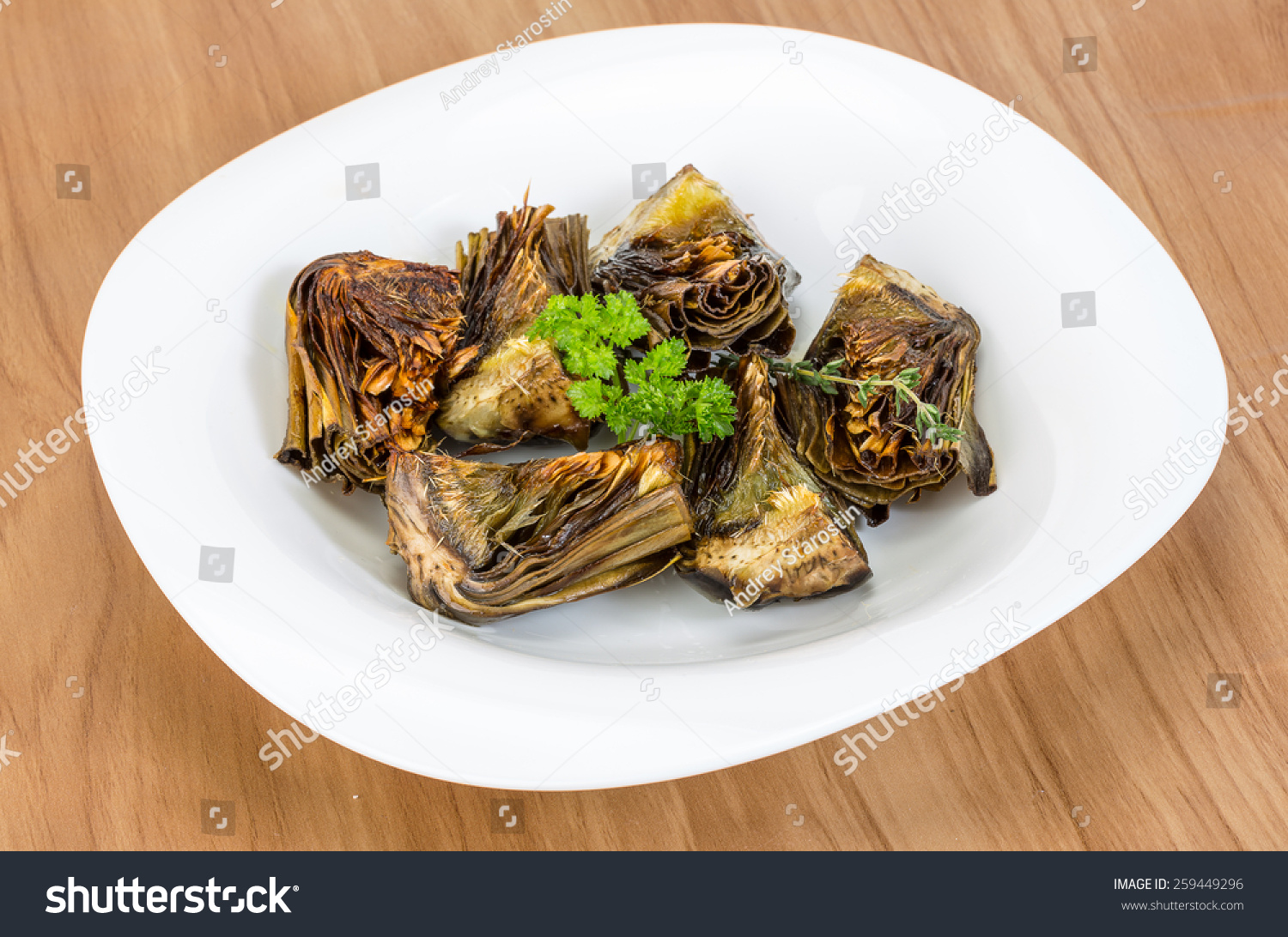 Grilled artishokes with parsley on the wood background #259449296