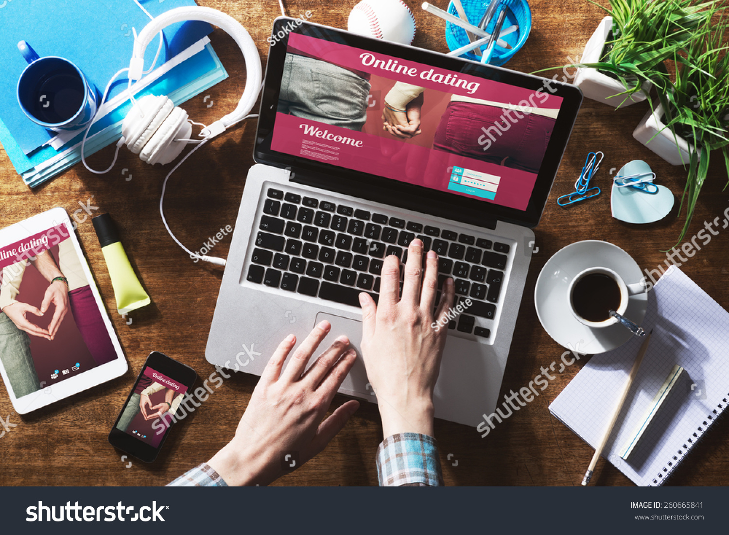 Online dating website on a laptop display, hardwood desktop and stationery on background #260665841