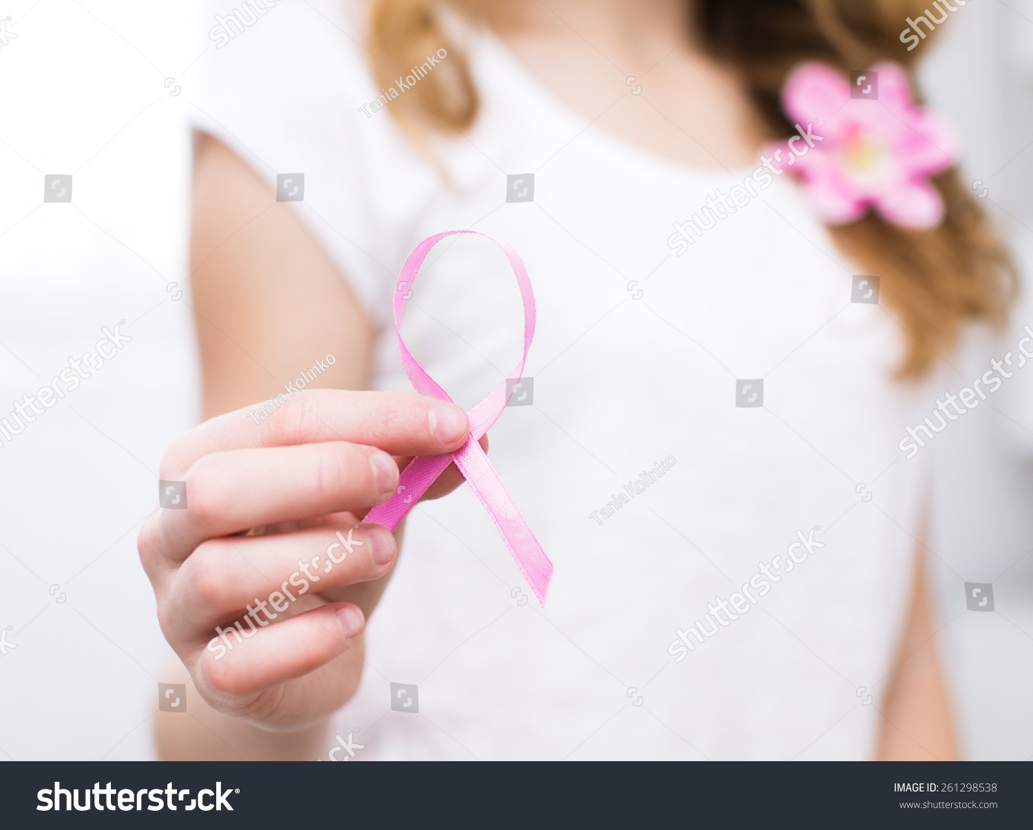 girl  holding pink breast cancer awareness ribbon #261298538