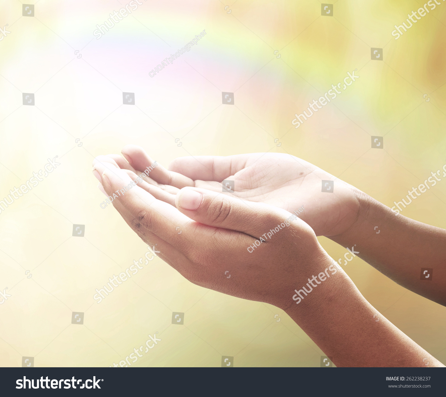 Offering concept: Human open two empty hands with palms up over blurred rainbow nature background #262238237