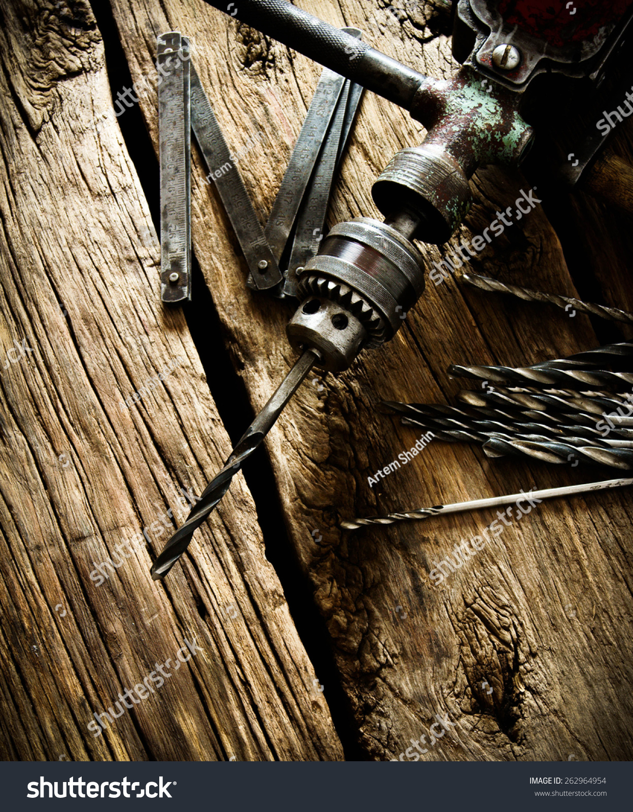 The old working tool. Old drill, a ruler and drills on a wooden background. #262964954