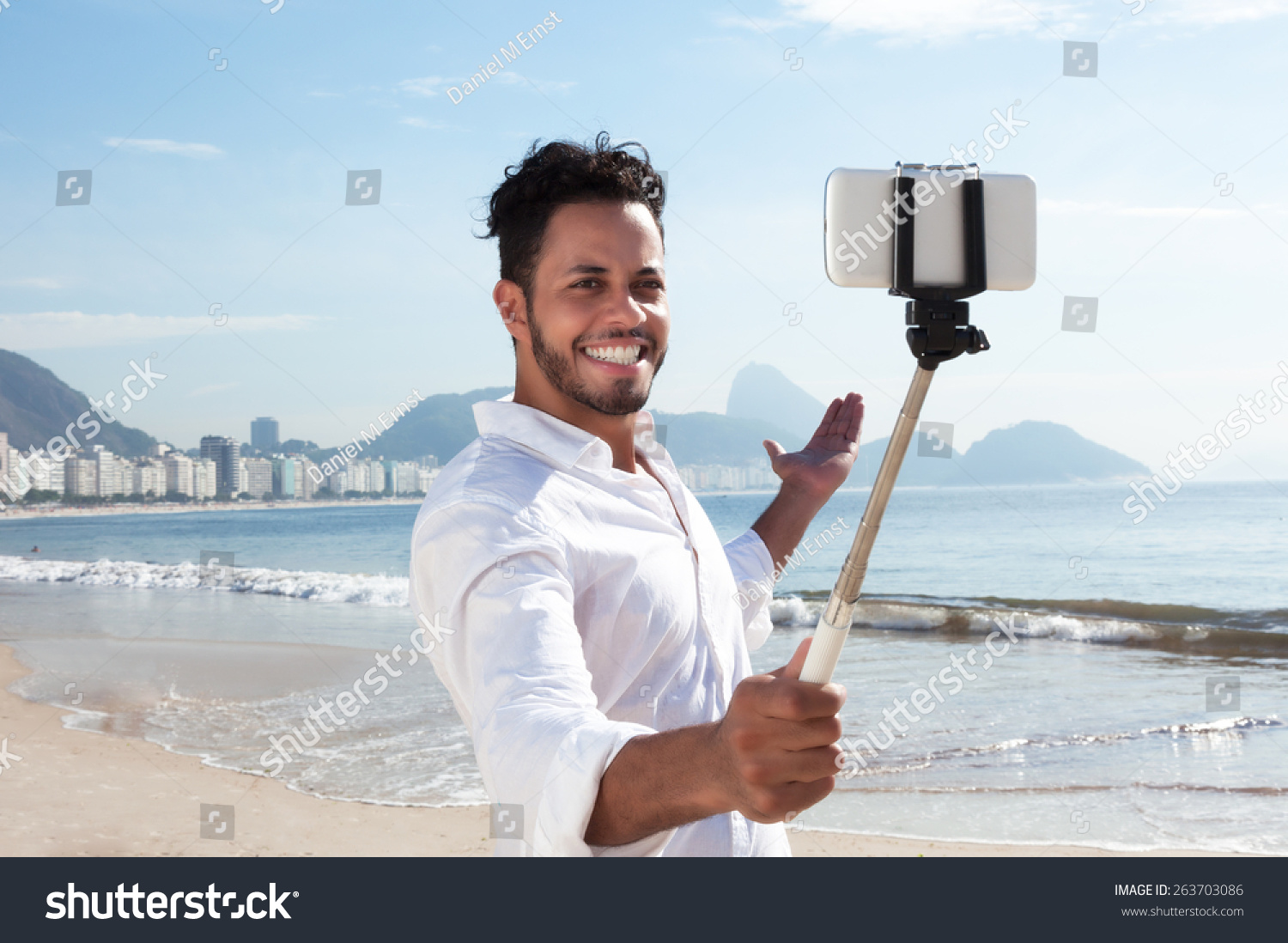 Brazilian man making selfie with a stick at Copacabana beach #263703086
