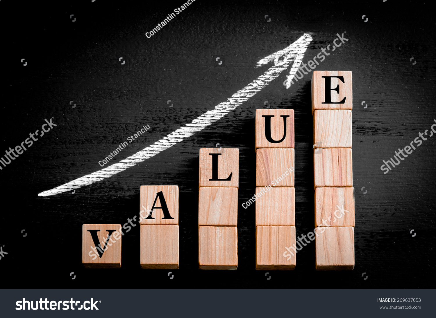 Word VALUE on ascending arrow above bar graph of Wooden small cubes isolated on black background. Chalk drawing on blackboard. Business Concept image. #269637053