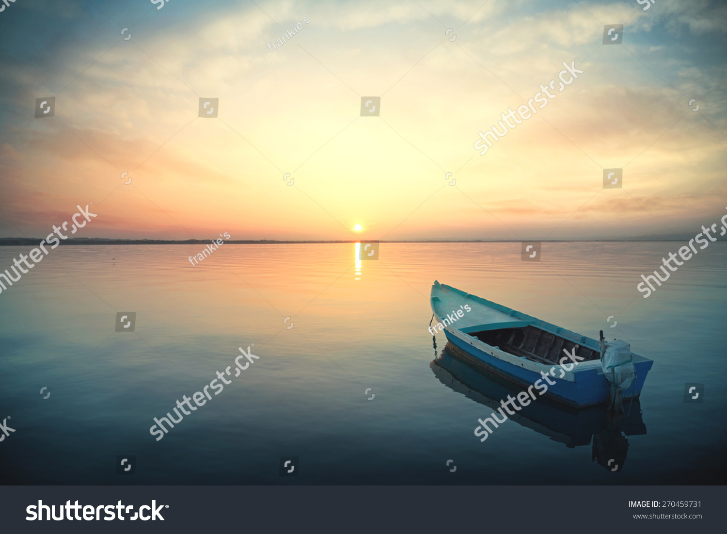 Canoe floating on the calm water under amazing sunset #270459731