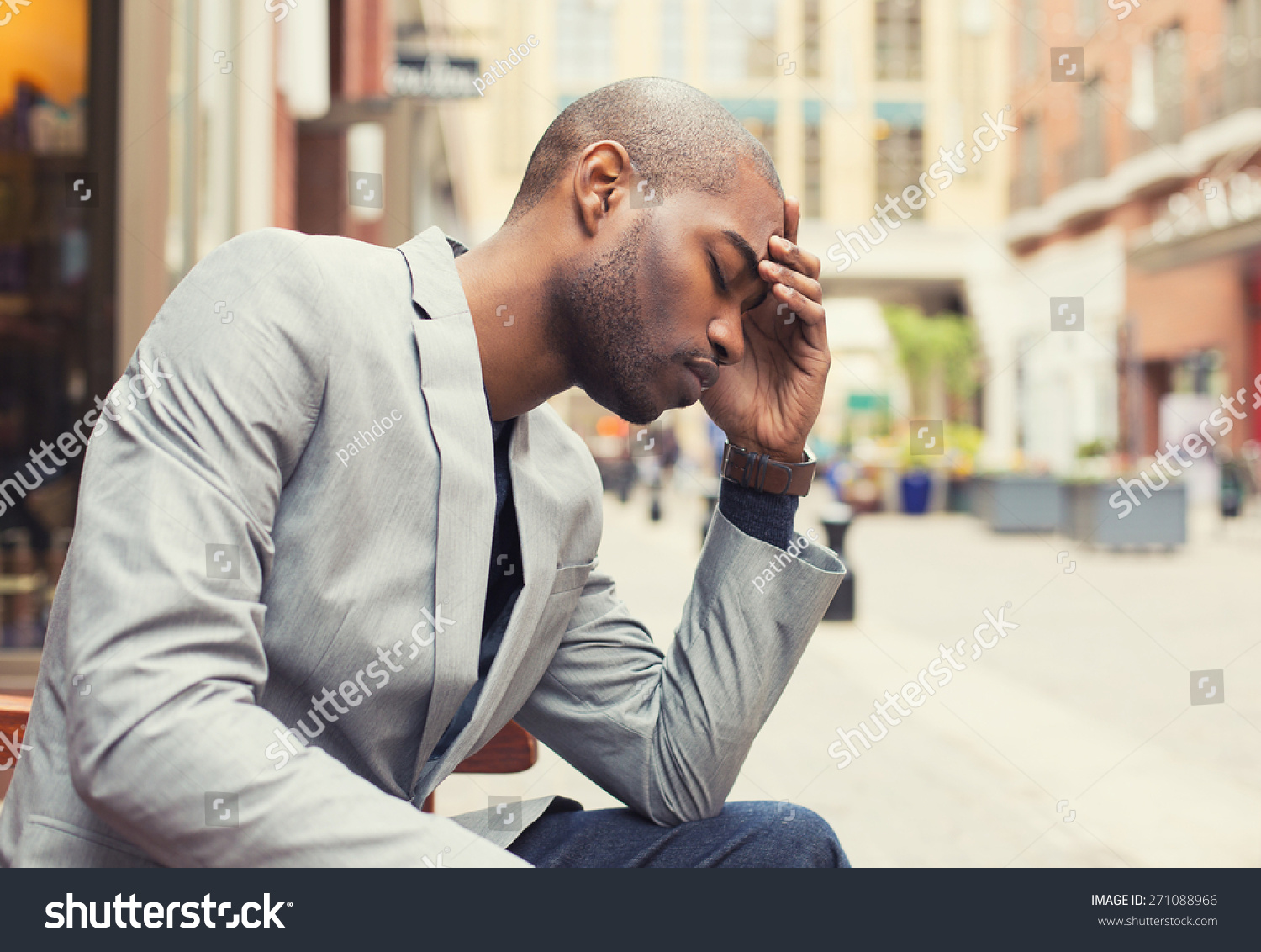 Portrait stressed young man hands on head with bad headache isolated city street background. Negative human emotion facial expression feeling #271088966