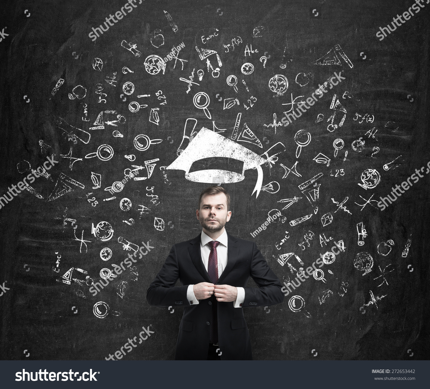 Young handsome businessman is thinking about education at business school. Drawn business icons over the dark concrete wall. Graduation hat. #272653442