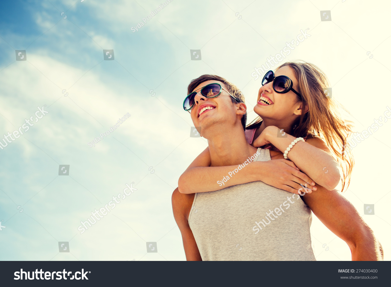 holidays, vacation, love and friendship concept - smiling couple having fun over sky background #274030400