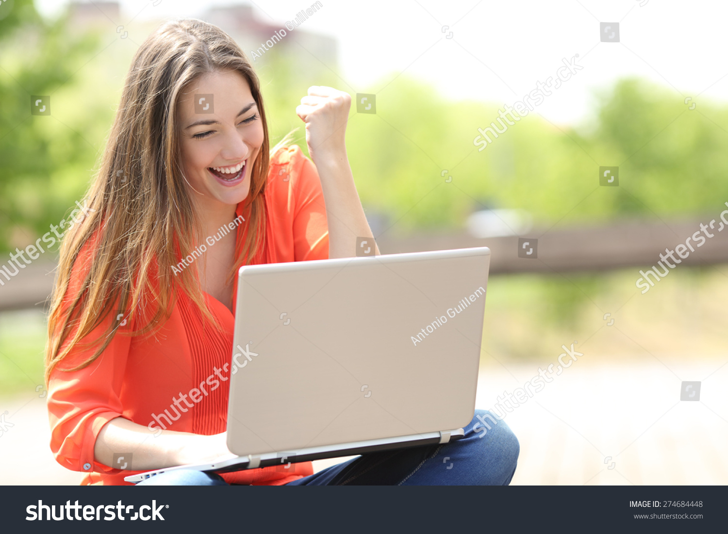 Euphoric woman searching job with a laptop in an urban park in summer #274684448