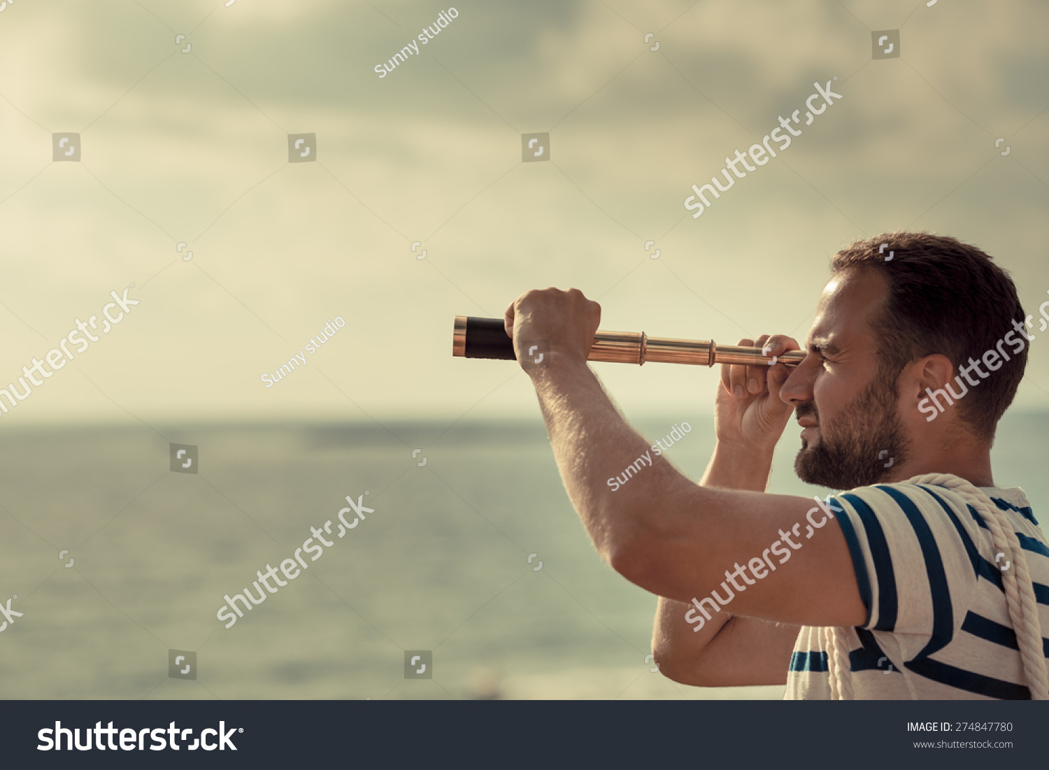 Sailor man looking through the binoculars against blue sky background #274847780