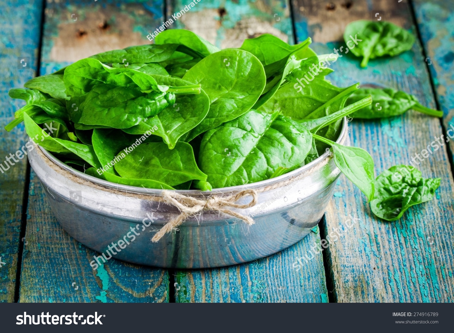 raw fresh organic spinach in a bowl on wooden rustic table #274916789