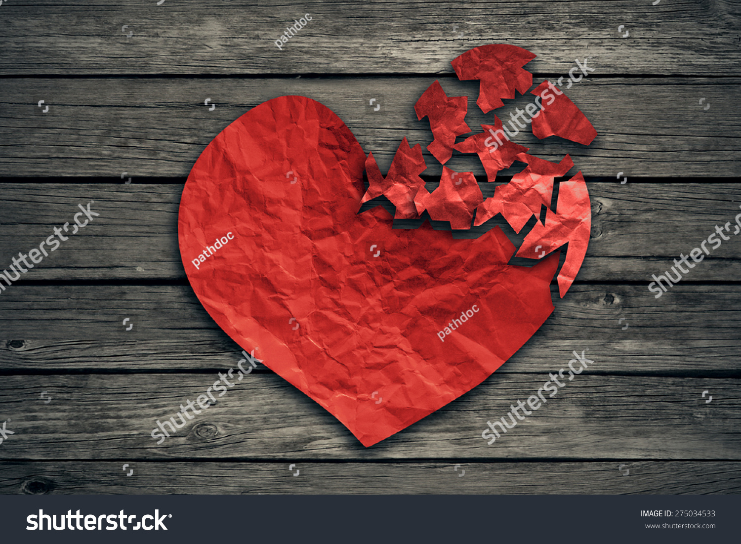 Broken heart breakup concept separation and divorce icon. Red crumpled paper shaped as a torn love on old wood symbol of medical cardiovascular health care problems due to illness #275034533