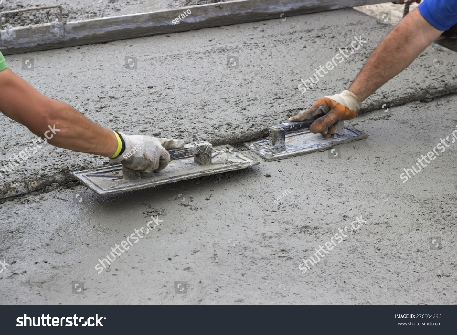 Leveling concrete with trowels, mason hands spreading poured concrete. Selective focus.
 #276504296