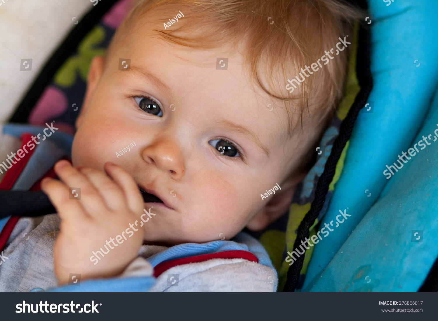 lying baby, smiling baby, baby has something in mouth, hold with teeth, lying in deck chair for baby #276868817