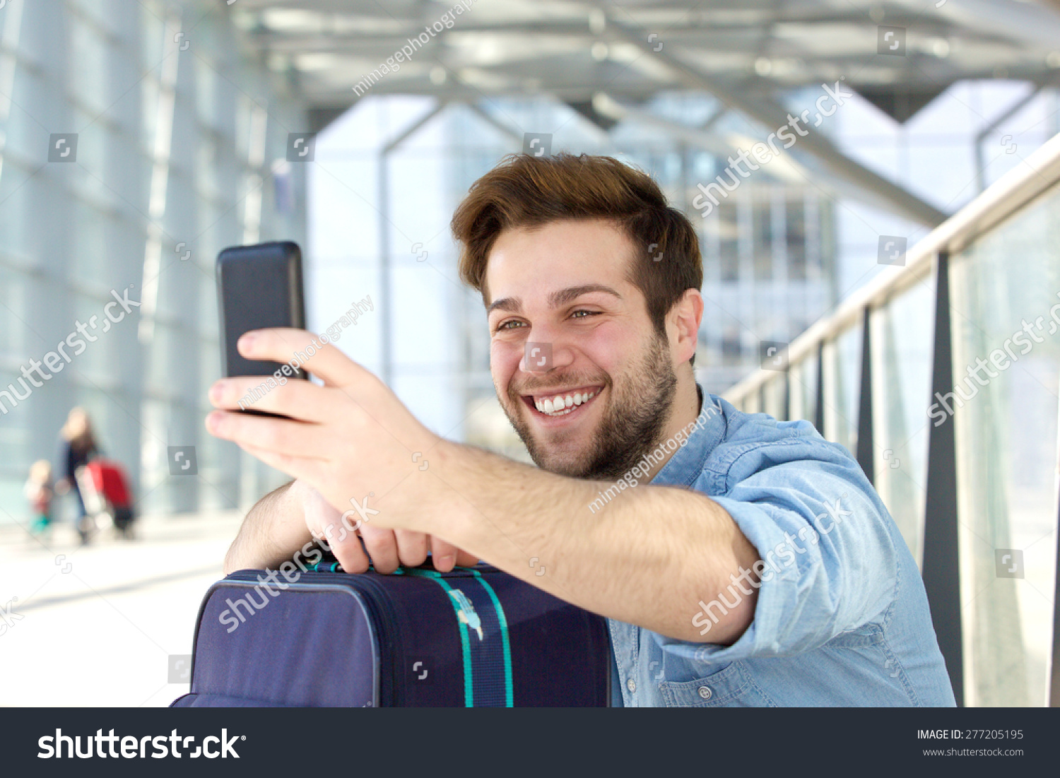 Portrait of a young man laughing and taking selfie #277205195