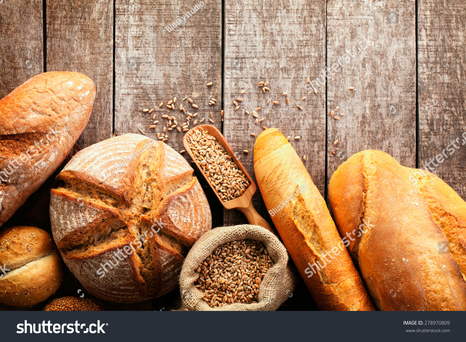 Assortment of baked bread on wooden table background #278970809