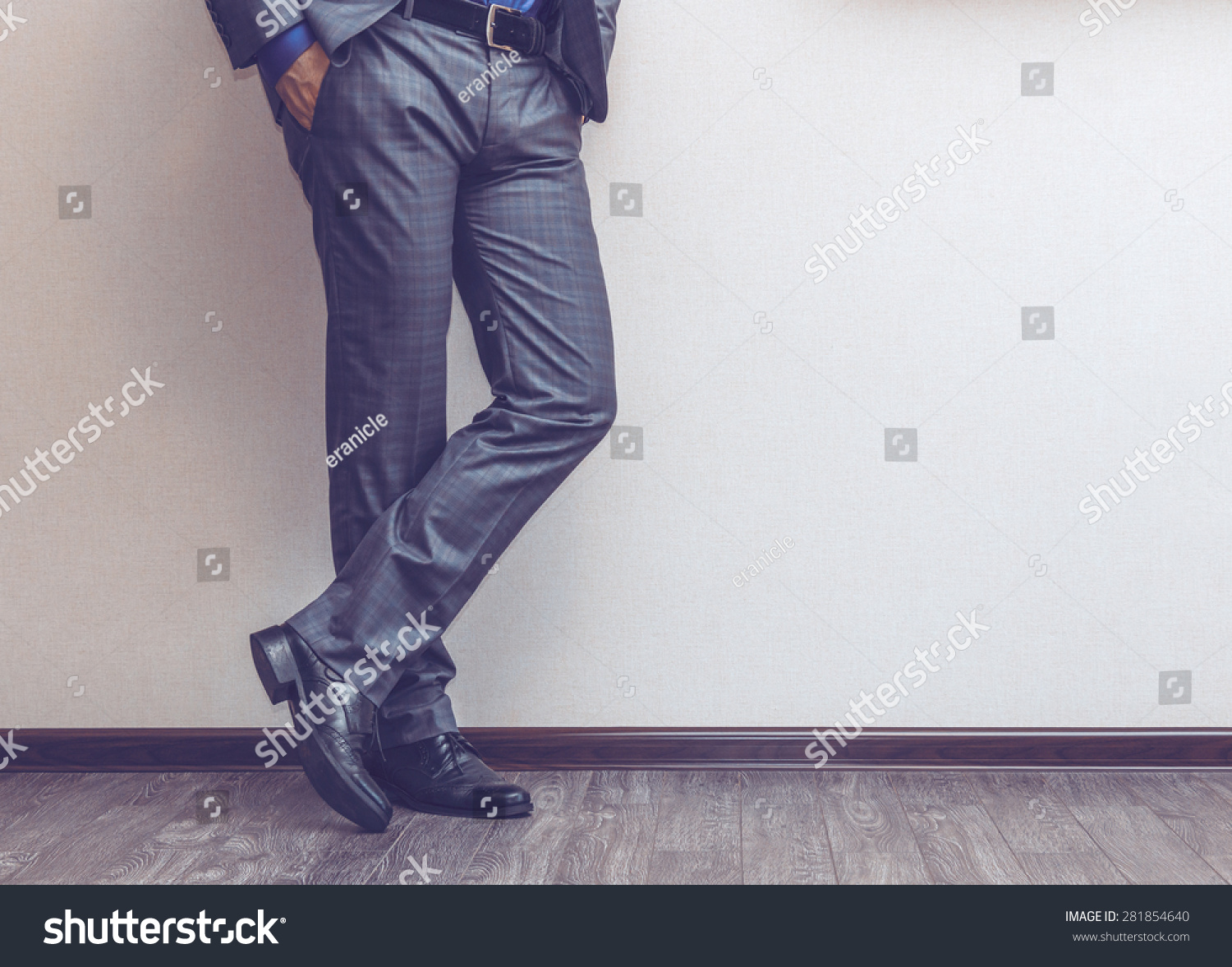 Young fashion businessman's legs in classic suit and shoes on wooden floor #281854640