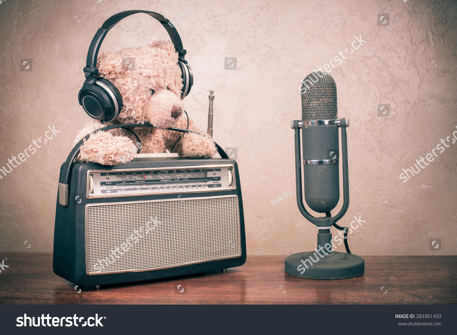 Retro radio from 60s, Teddy Bear toy with headphones and old microphone on table. Vintage instagram style filtered conceptual photo #283361450