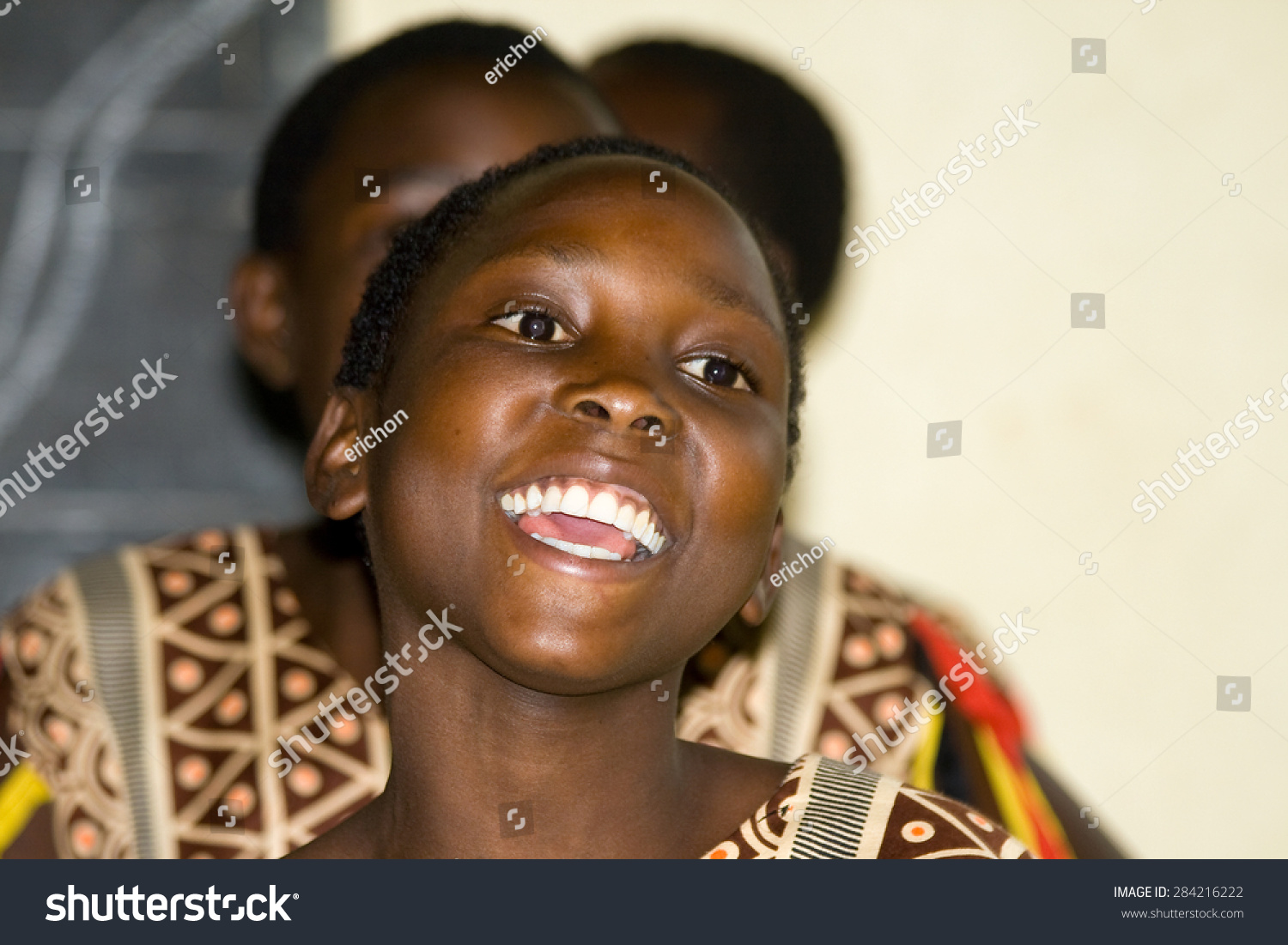 LAKE NKURUBA, UGANDA - AUGUST 28, 2010: Close up of an unidentified happy teenager sings and dances a traditional performance in the Nkuruba Culture Entertainment Club.  #284216222