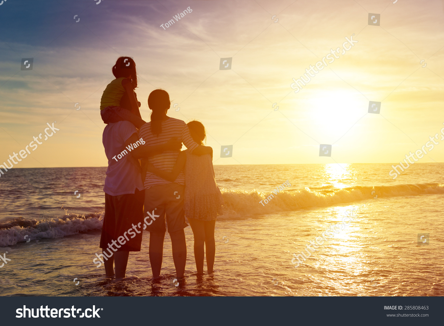 happy family watching the sunset on the beach #285808463