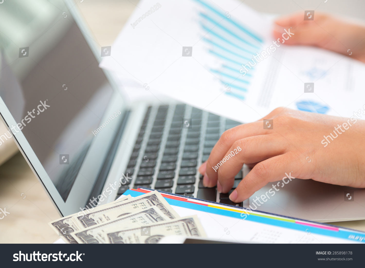 Business woman hand typing on laptop keyboard with Financial charts on the table #285898178