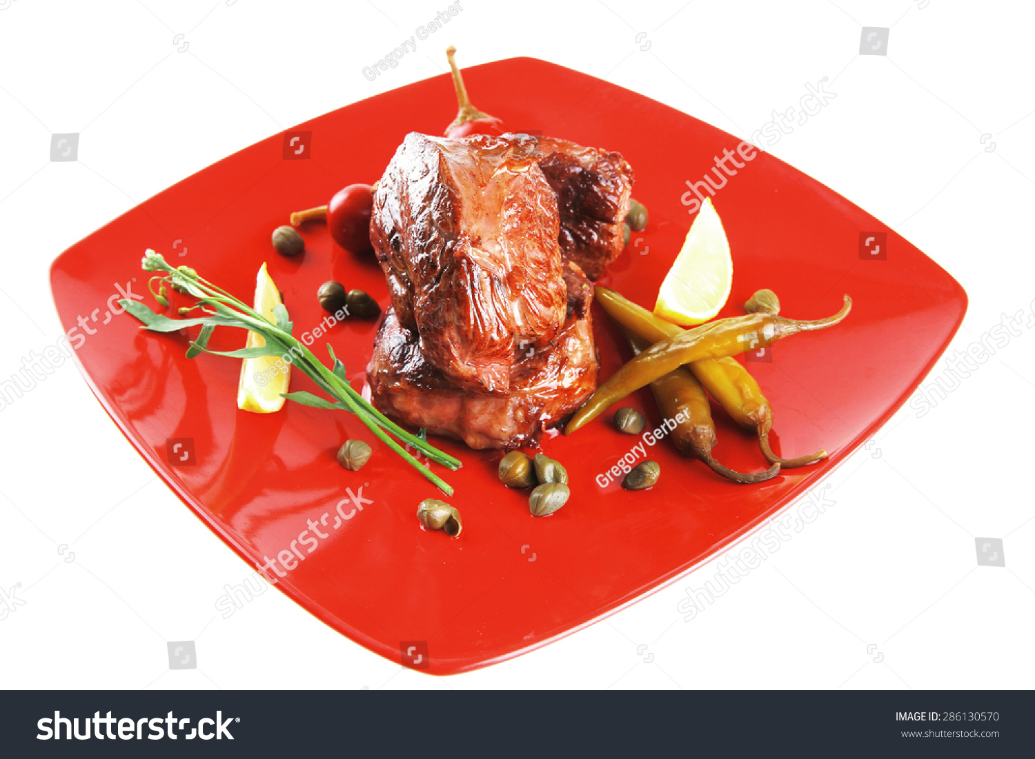 roast beef meat fillet medallion with cherry tomatoes and hot peppers on red plate isolated on white background #286130570