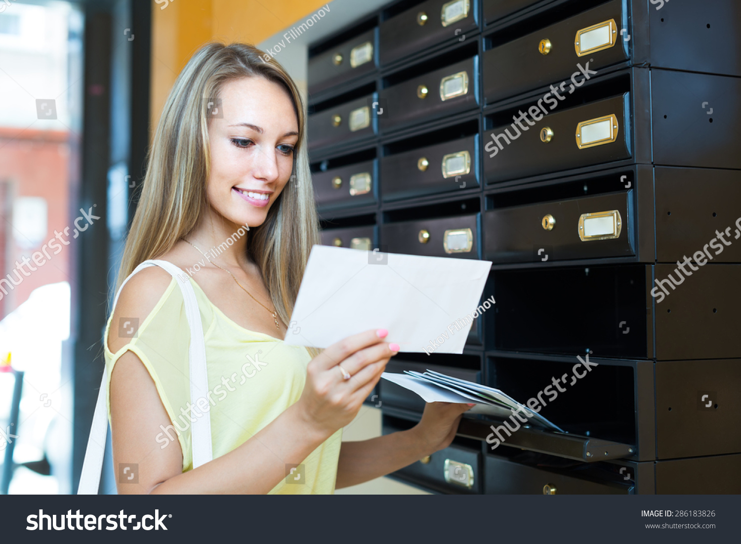 Smiling girl taking junk mail out the posting box #286183826