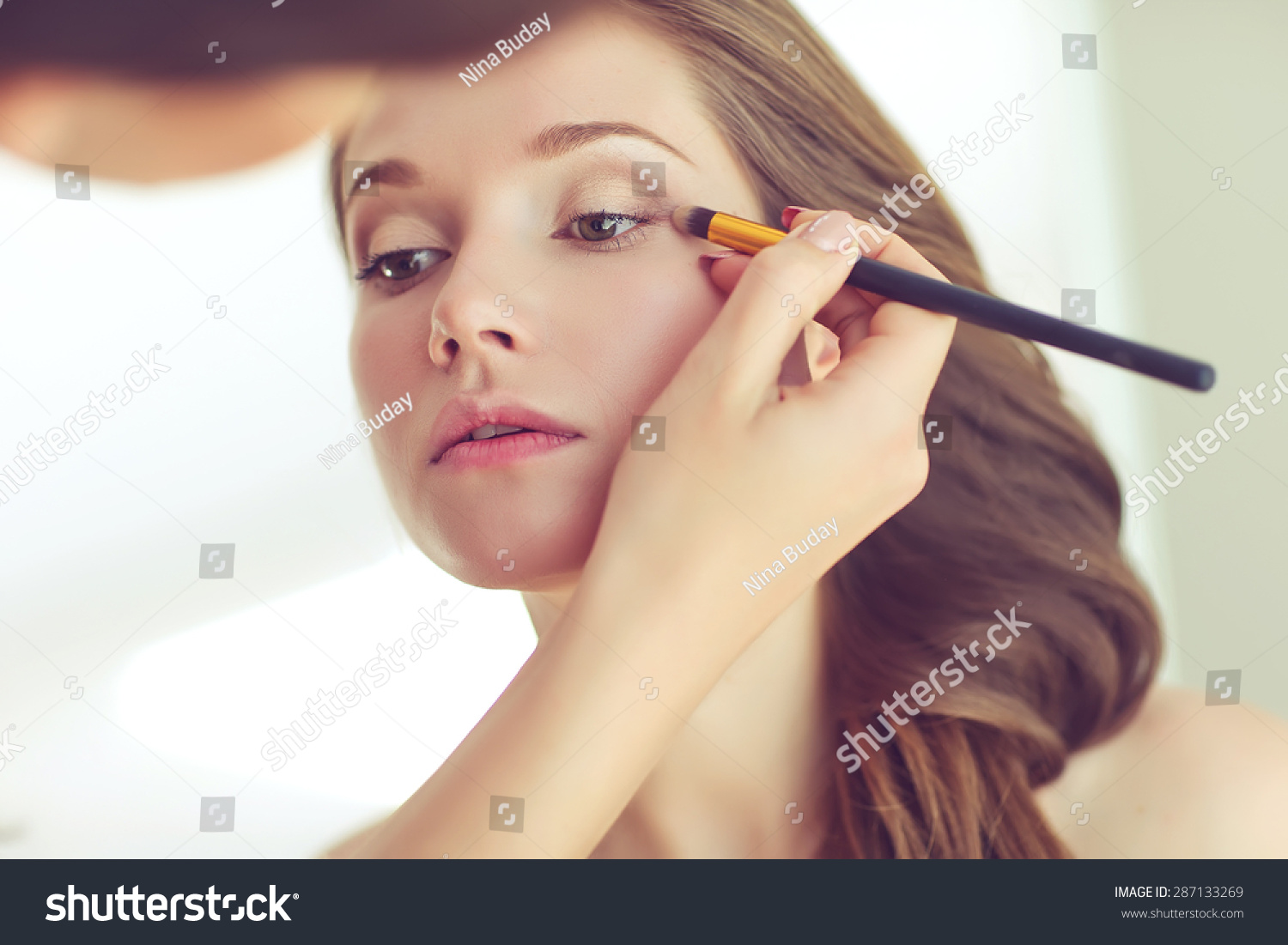 Backstage scene: Professional Make-up artist doing glamour model makeup at work  #287133269