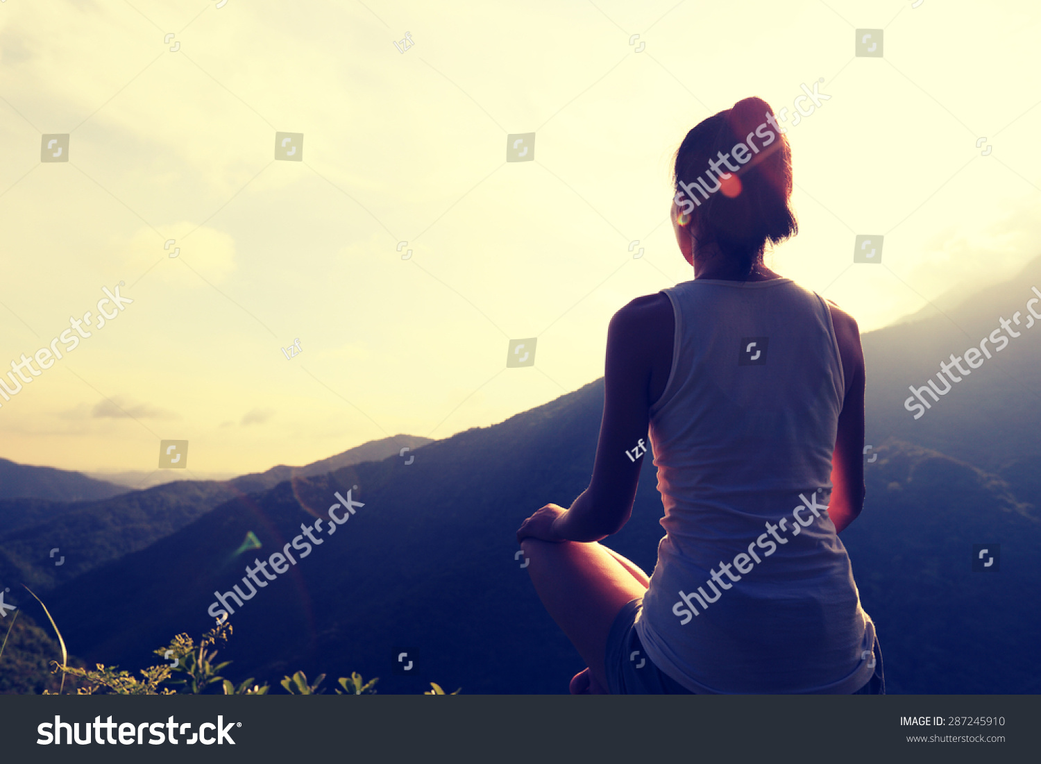 young yoga woman at sunrise mountain peak #287245910