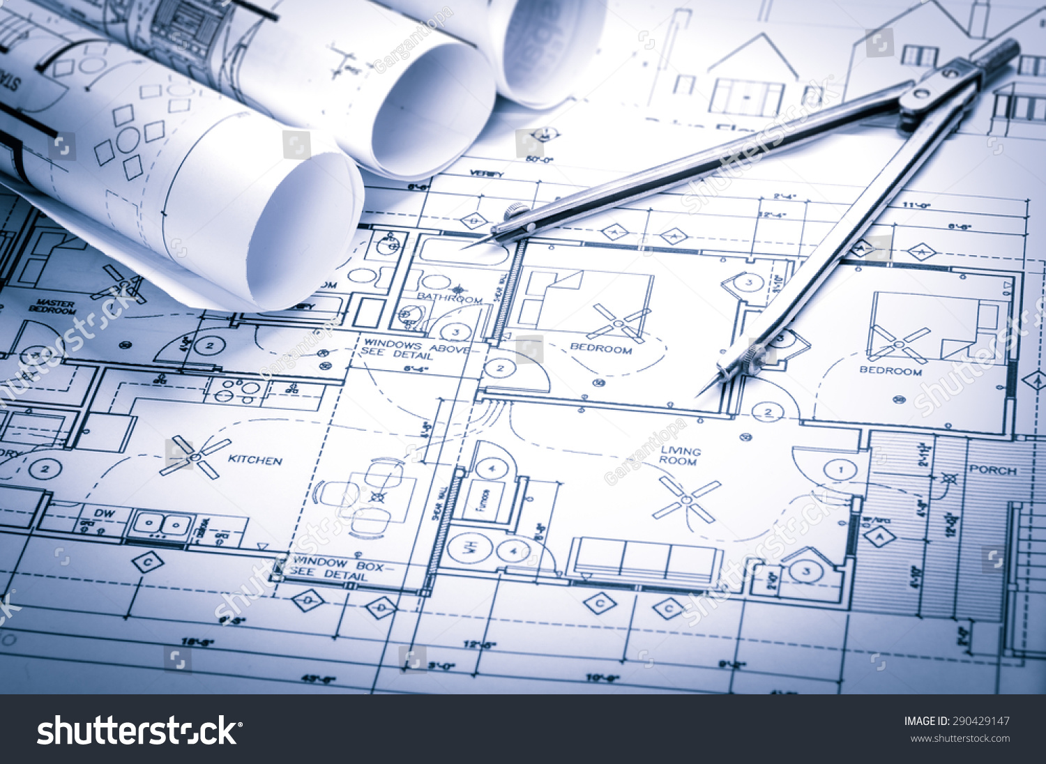 rolls of architecture blueprints and house plans on the table and drawing compass #290429147